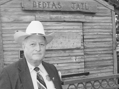 Sheriff Sowell stands in front of the original structure of the former jail located in Bedias, Texas.